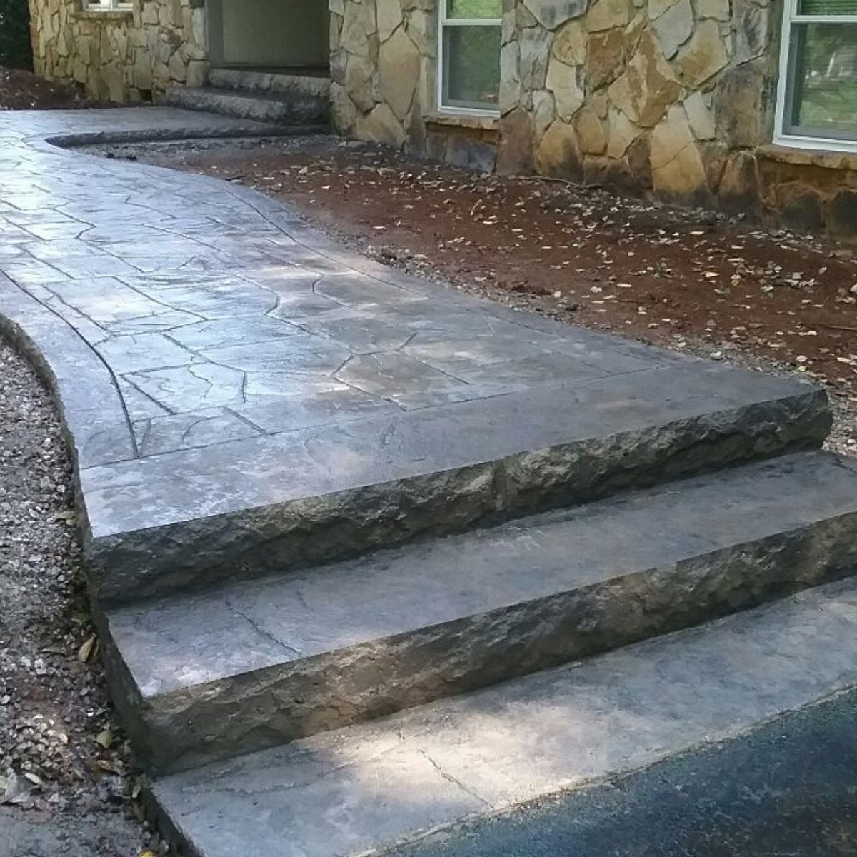 Stone textured steps with stamped concrete patio